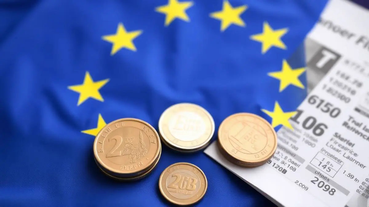 Zastava Evropske unije z evrskimi kovanci in finančnimi dokumenti — regulativa UCITS za investicijske sklade